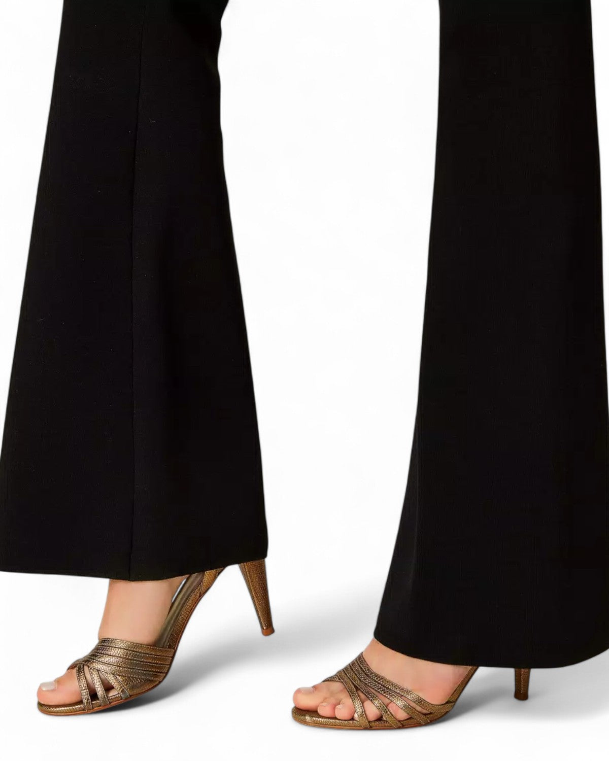 Dettaglio orlo pantaloni flare maglia neri con sandali dorati, stile raffinato e moderno per la stagione invernale.