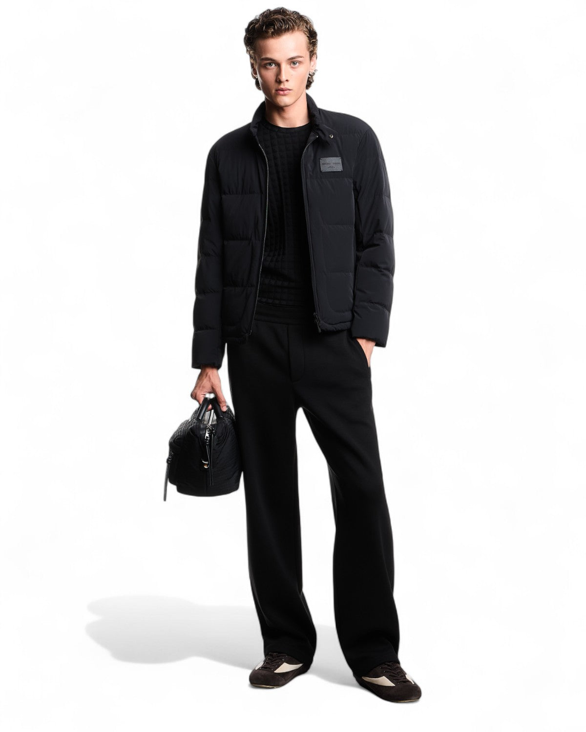Look completo con piumino trapuntato uomo spandex nero, abbinato a pantaloni eleganti e borsa, ideale per l'inverno FW26.