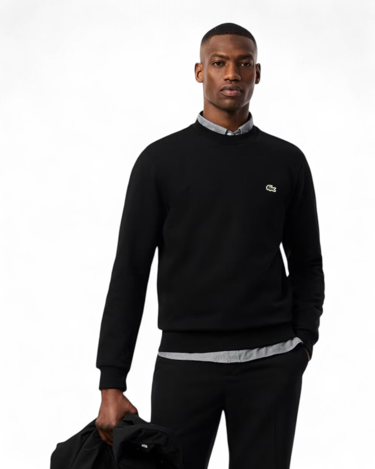 Modello indossa felpa girocollo in pile Lacoste nera con logo ricamato, perfetta per look casual da uomo in inverno.