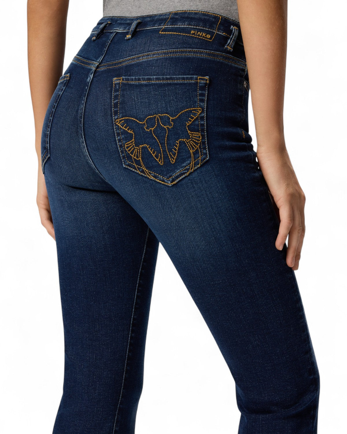 Dettaglio tasca posteriore dei Jeans Flared Pinko con ricamo Love Birds dorato, simbolo iconico del brand per un tocco distintivo.