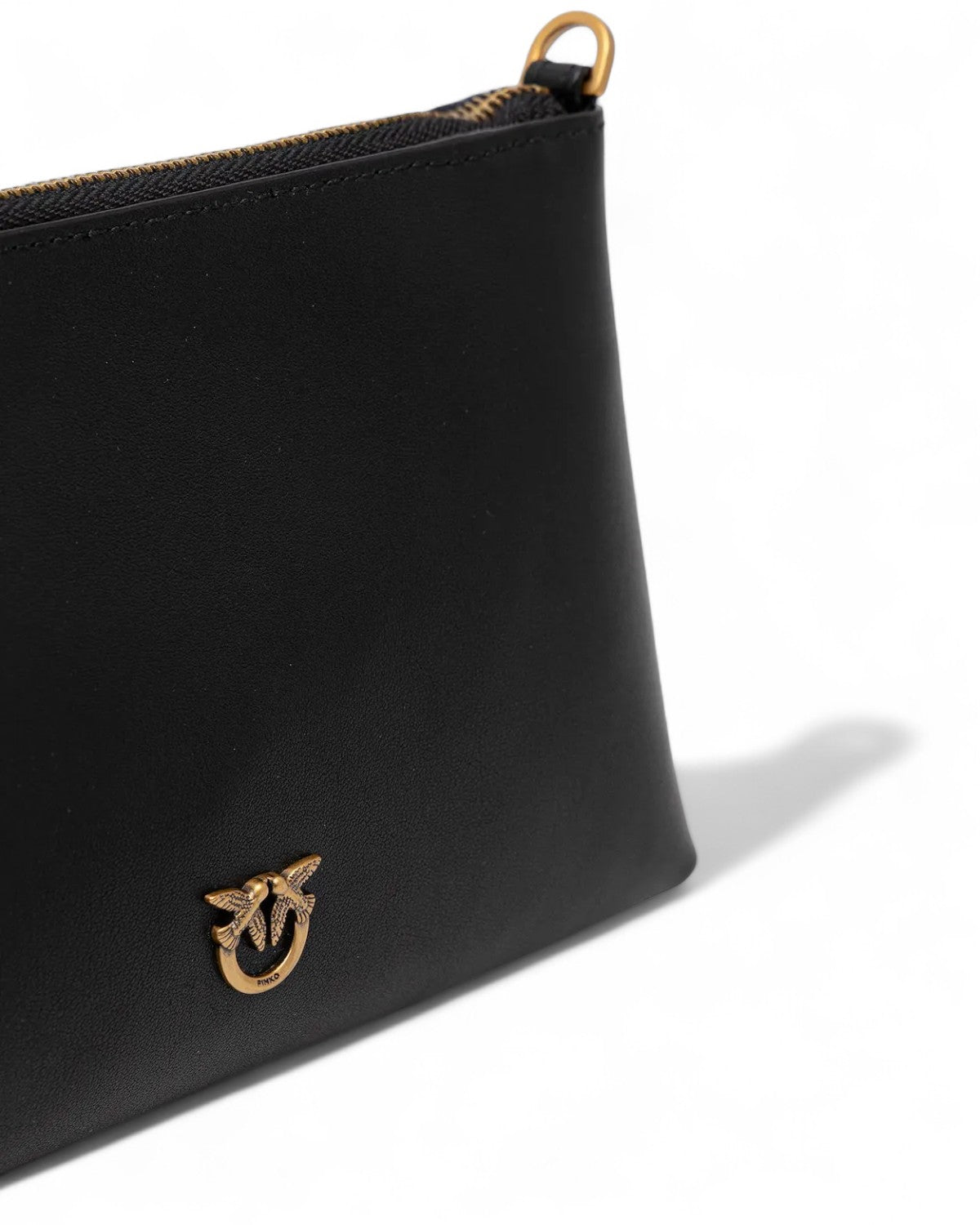 Dettaglio logo dorato sulla Pochette Pinko in pelle naturale nera, simbolo di eleganza e stile per accessori da donna FW26.