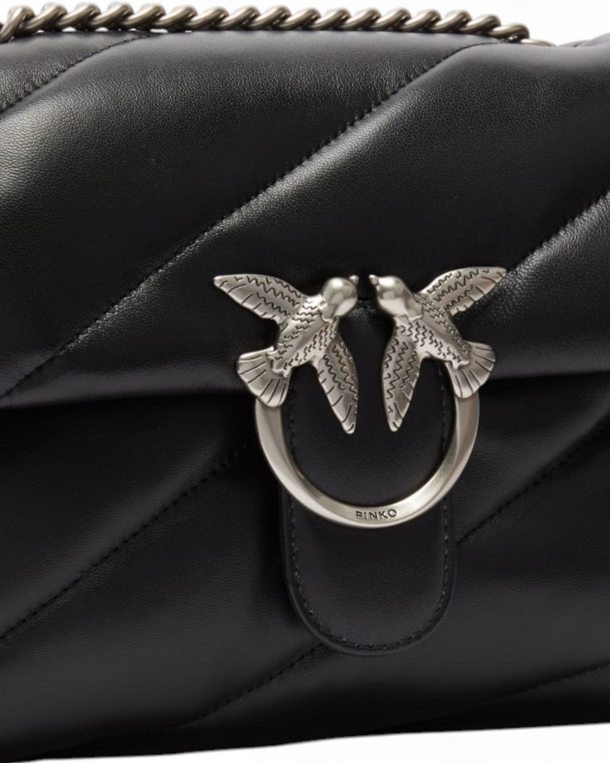 Dettaglio della fibbia Love Birds in metallo sulla Borsa Love Puff in pelle trapuntata, simbolo di eleganza e stile iconico.