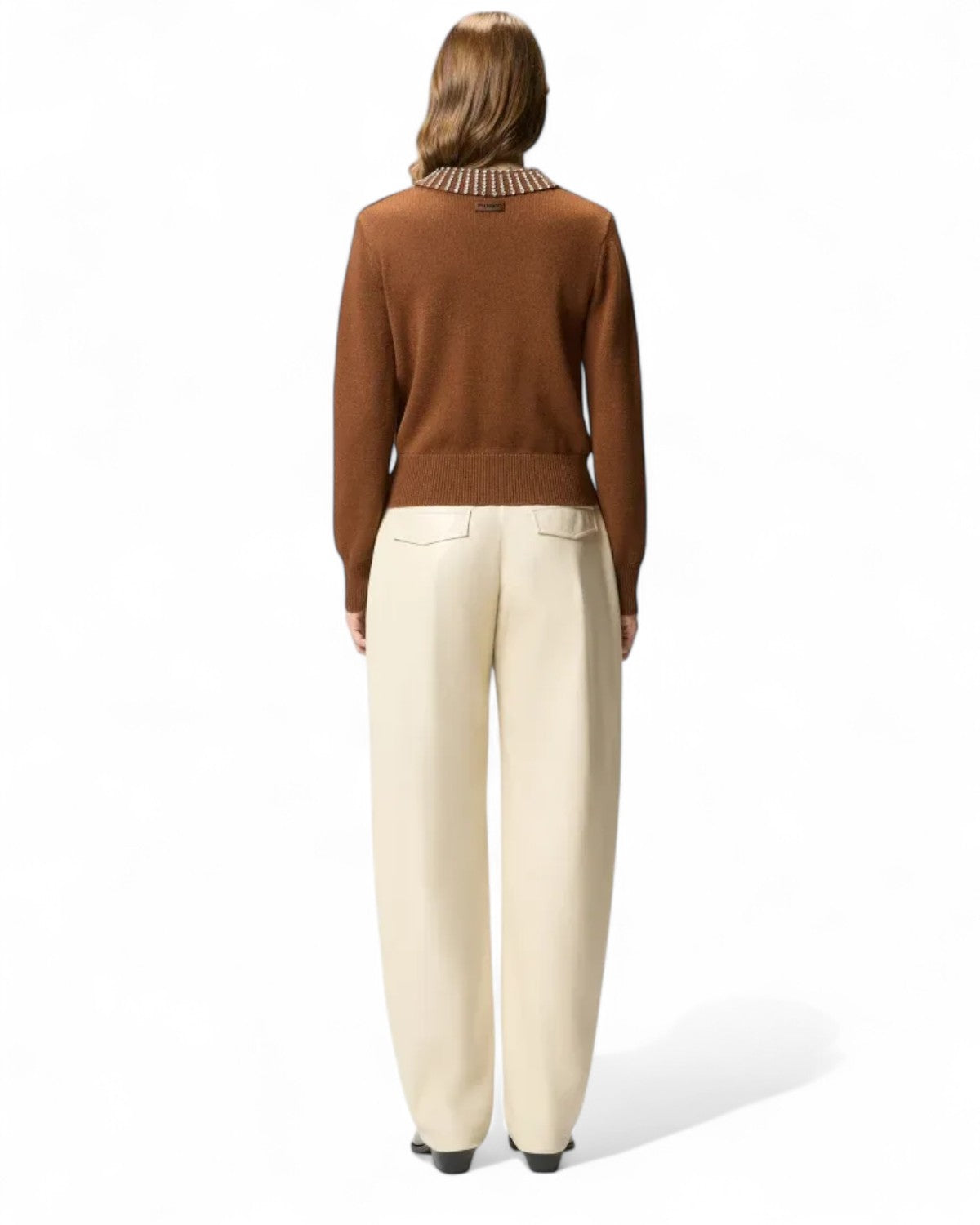 Vista posteriore della Maglia Polo con Strass PINKO indossata, abbinata a pantaloni chiari per un outfit sofisticato e femminile.