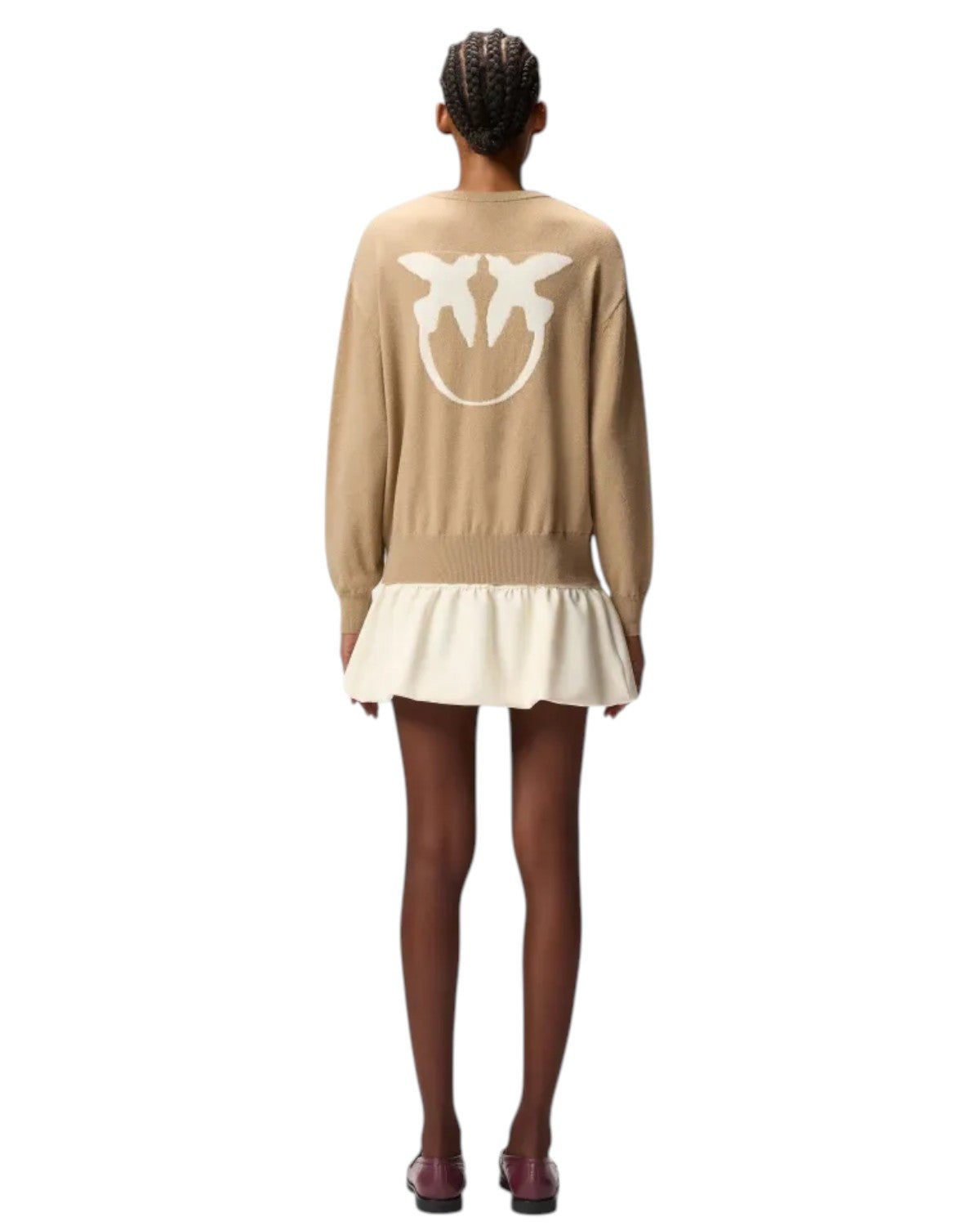 Vista posteriore del maglione Pinko con maxi logo Love Birds, abbinato a minigonna chiara per un look invernale elegante e contemporaneo.