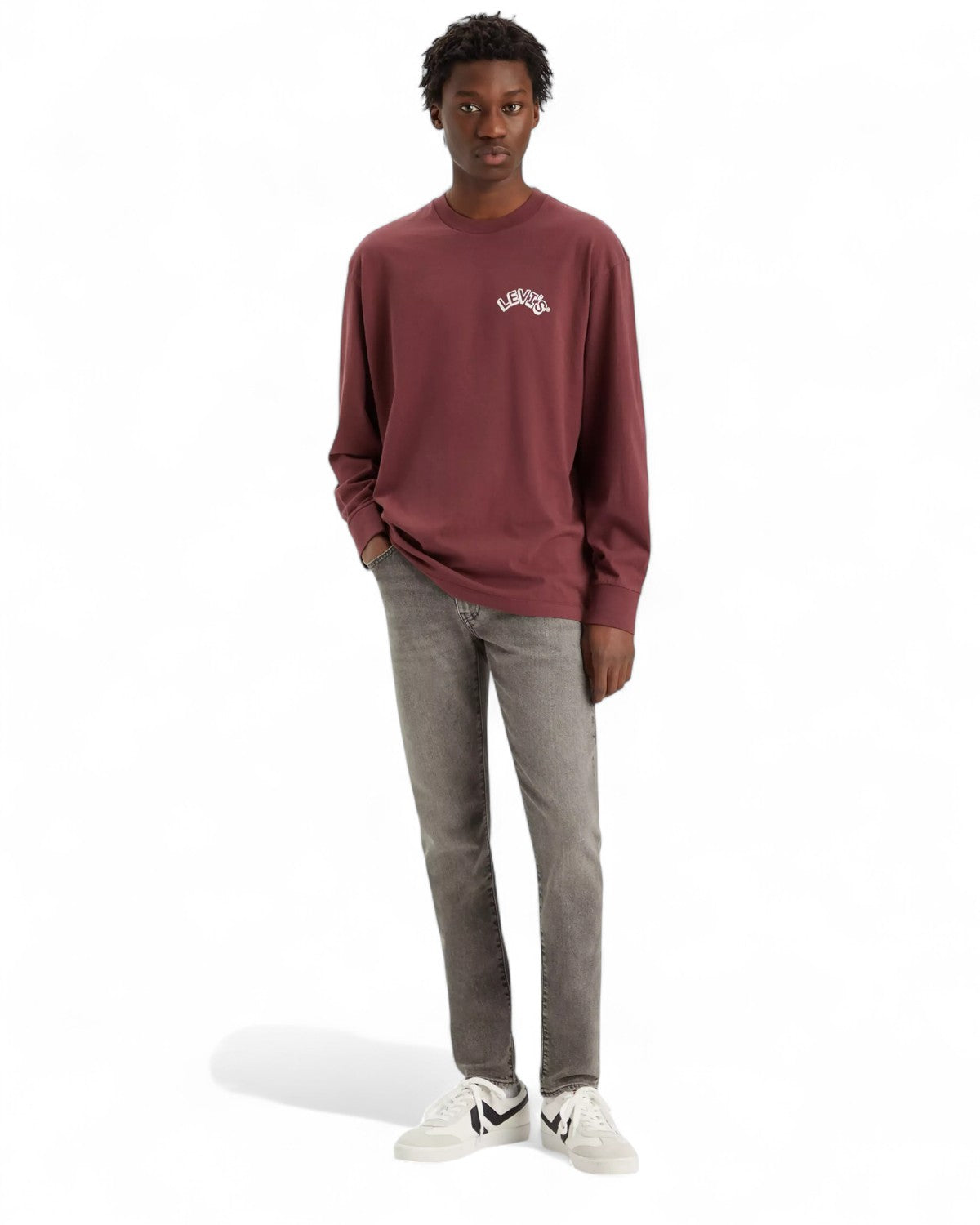 Modello indossa jeans Levi's 512 Slim Taper grigi con vestibilità slim e sneakers bianche, ideale per outfit casual invernali.